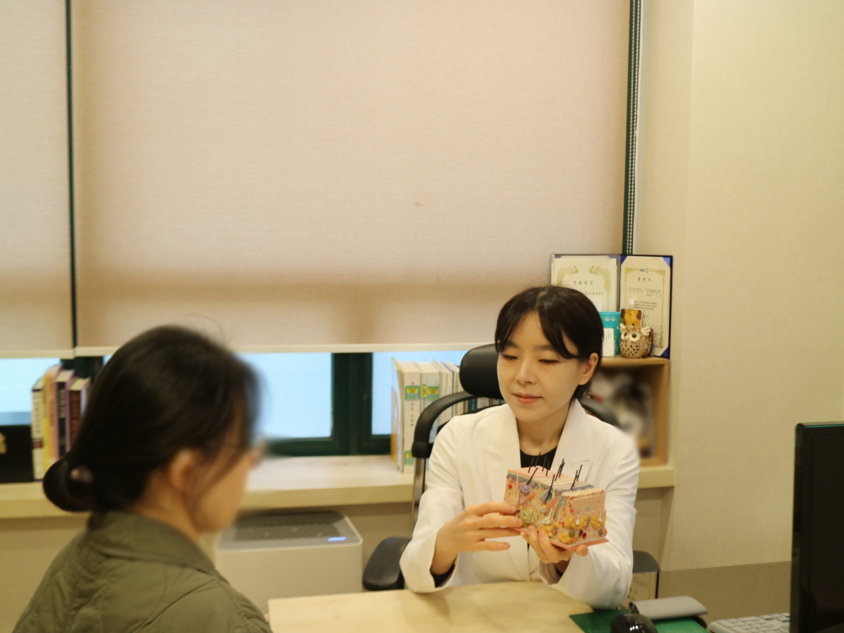 주지언 대표원장이 피부 모형으로 피부 장벽의 구조를 설명합니다.
